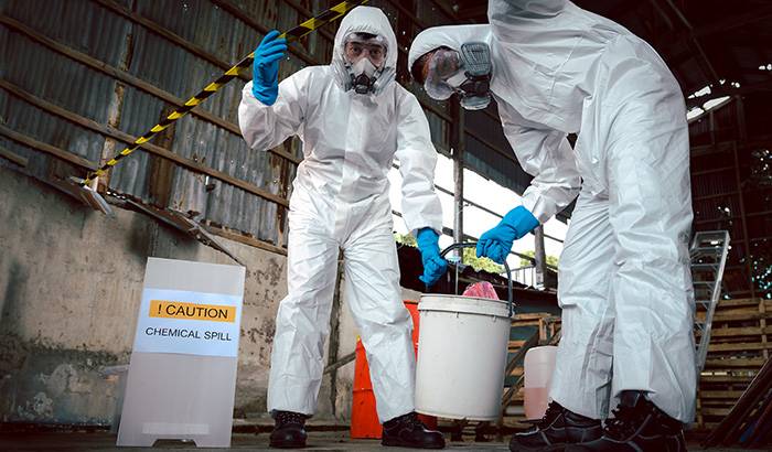 Workers clean chemical spill in protective suits